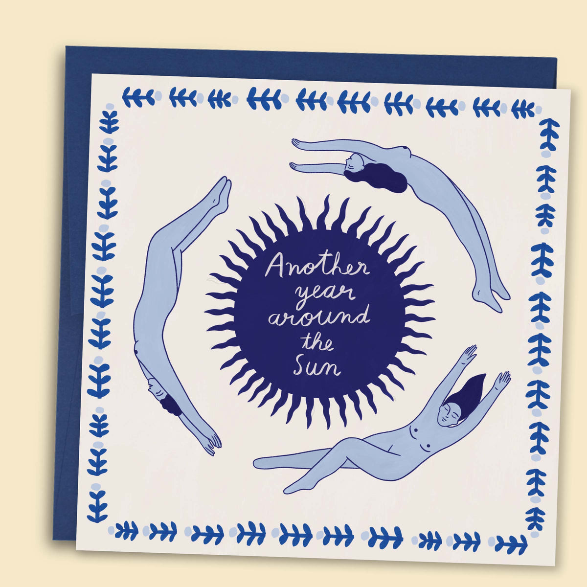 A greeting card with a hand-drawn illustration by Constanza Goeppinger of people floating arounda sun, surrounded by a blue border, with the text 'Another year around the Sun'. Australian-made greeting card by Papernest.