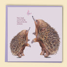 Greeting card with two echidnas and a butterfly on a light purple background