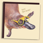 Greeting card with a platypus wearing windscreen wiper Elton John glasses illustration. Greeting reads, "You're Spec-tacular"